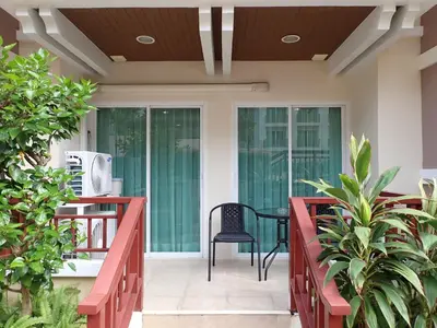 a patio with a black chair and a table at Private apartment at Phuket Villa Condo in Patong Beach