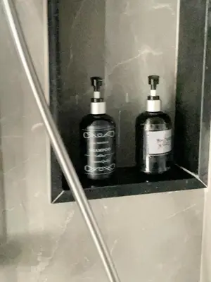 two bottles of soap sitting on a shelf in a shower at EMERALD TERRACE CONDO 52-FAMILY 1 Bedroom POOL VIEW in Patong Beach