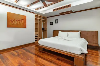 a bedroom with a bed and a painting on the wall at Villa Suriya B2 in Patong Beach
