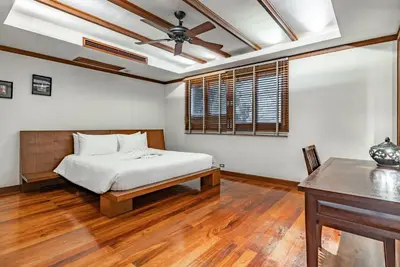 a bedroom with a bed and a table in it at Villa Suriya B2 in Patong Beach