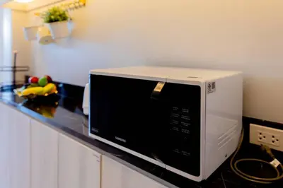 a microwave sitting on a counter in a kitchen at Pool Villa No 10 by Duangtham in Ban Khlong Haeng