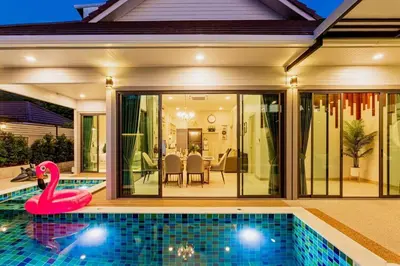 a swimming pool with a pink swan in front of a house at Pool Villa No 10 by Duangtham in Ban Khlong Haeng