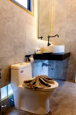 a bathroom with a white toilet and a sink at Pool Villa No 10 by Duangtham in Ban Khlong Haeng