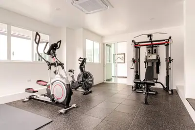 a gym with two treadmills and two exercise bikes at Kyerra 88-16 An exquisite mansion with eclectic interiors in Phuket Town