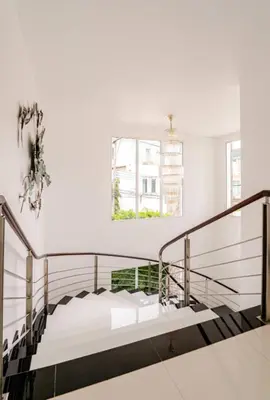 a staircase in a white room with white walls at Kyerra 88-16 An exquisite mansion with eclectic interiors in Phuket Town