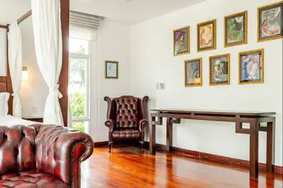 a bedroom with a couch and a table and a chair at Kyerra 88-16 An exquisite mansion with eclectic interiors in Phuket Town