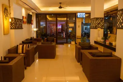 a lobby with couches and tables in a building at The Star House in Patong Beach