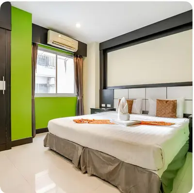 a bedroom with a large bed with a green wall at The Star House in Patong Beach