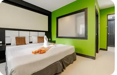 a bedroom with a large bed with a green wall at The Star House in Patong Beach