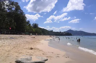 a group of people in the water on a beach at Cozy Surin apartment at 6 Avenue by Lofty in Surin Beach