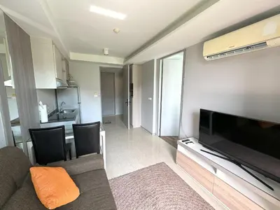 a living room with a couch and a flat screen tv at Cozy Surin apartment at 6 Avenue by Lofty in Surin Beach