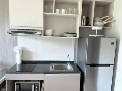 a small kitchen with a refrigerator and a sink at Cozy Surin apartment at 6 Avenue by Lofty in Surin Beach