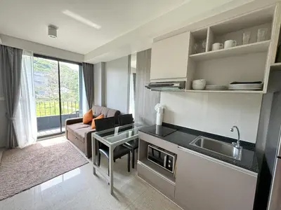 a kitchen and living room with a couch and a sink at Cozy Surin apartment at 6 Avenue by Lofty in Surin Beach