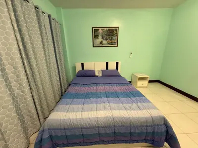 a bedroom with a bed with a blue and white comforter at Best Rent a Room in Nai Yang Beach