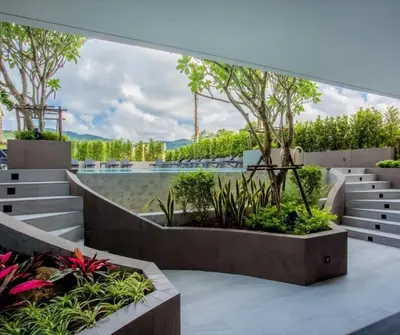 a courtyard with benches and trees and plants at Modern Condo near the Beach - NV531 in Phuket Town