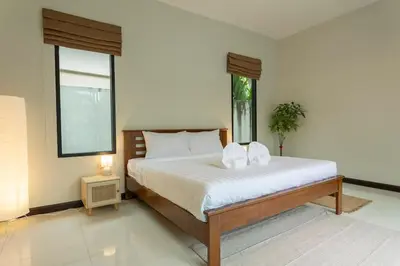 a bedroom with a bed with white sheets and a window at 2 Beds large pool night market Soi Namjai v122 in Rawai Beach