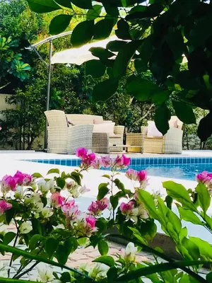 a pool with chairs and flowers in front of it at Studio Room with private kitchen and Bathroom in Ban Phlu Yai