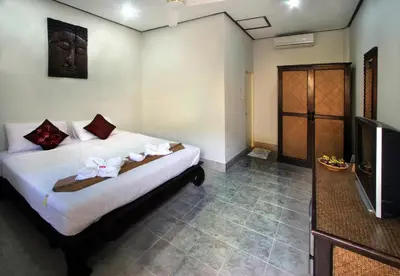 a bedroom with a bed and a tv in a room at Karon Pool Hotel in Karon Beach