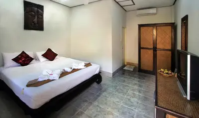 a bedroom with a bed and a tv and a room at Karon Pool Hotel in Karon Beach