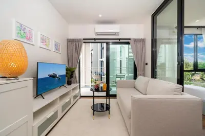 a living room with a couch and a tv at The Halo 1 Naiyang Beach in Nai Yang Beach
