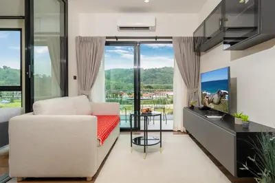 a living room with a couch and a tv at The Halo 1 Naiyang Beach in Nai Yang Beach