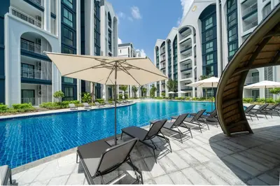an outdoor swimming pool with chairs and an umbrella at The Halo 1 Naiyang Beach in Nai Yang Beach
