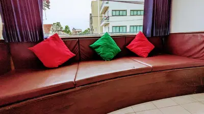 three colorful pillows sitting on a brown couch at Heaven House Restro & Bar in Patong Beach