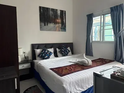 a bedroom with a bed with a white animal laying on it at Heaven House Restro & Bar in Patong Beach
