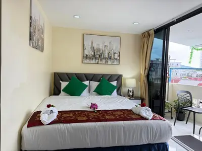 a bedroom with a large bed with green pillows at Heaven House Restro & Bar in Patong Beach