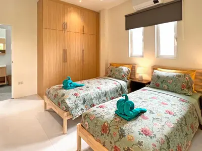 two beds in a room with blue slippers on them at At the Beach New comfortable Pool Home, Ao Yon Beach, Phuket in Ban Ao Makham