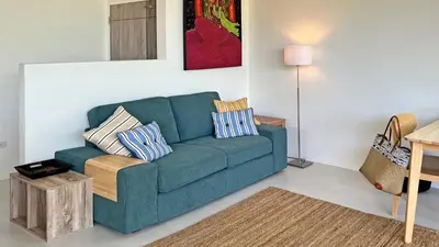 a living room with a blue couch with pillows at At the Beach New comfortable Pool Home, Ao Yon Beach, Phuket in Ban Ao Makham