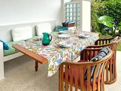 a table with a green vase on top of it at At the Beach New comfortable Pool Home, Ao Yon Beach, Phuket in Ban Ao Makham