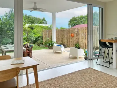 a living room with a sliding glass door to a patio at At the Beach New comfortable Pool Home, Ao Yon Beach, Phuket in Ban Ao Makham