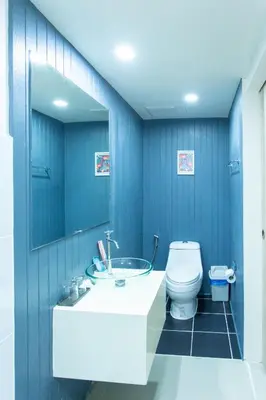 a blue bathroom with a sink and a toilet at The Light House at Town Phuket in Phuket Town