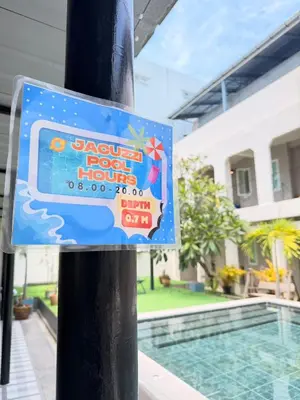 a sign on a pole next to a swimming pool at The Light House at Town Phuket in Phuket Town