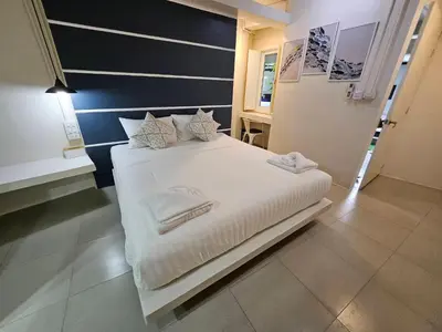 a bedroom with a bed with white sheets and pillows at The Light House at Town Phuket in Phuket Town