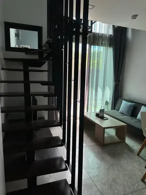 a black spiral staircase in a living room with a couch at Duplex apartment on Naiharn Beach A22 in Rawai Beach