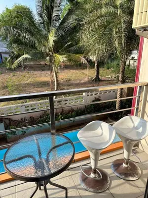 a balcony with a glass table and two stools at Nai Harn Beach Condo (P1) in Rawai Beach