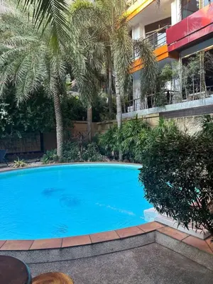 a large blue swimming pool in front of a building at Nai Harn Beach Condo (P1) in Rawai Beach