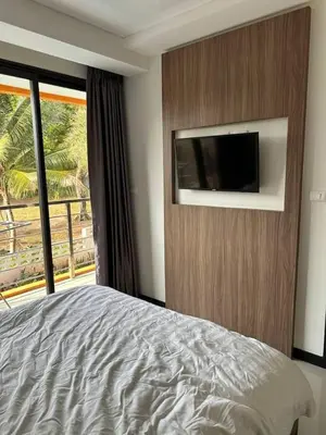 a bedroom with a bed and a flat screen tv at Nai Harn Beach Condo (P1) in Rawai Beach