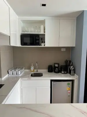 a kitchen with white cabinets and a sink at Spacious apartment 600m from the beach in Rawai Beach
