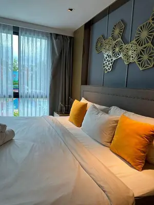 a bedroom with a large white bed with orange pillows at Spacious apartment 600m from the beach in Rawai Beach