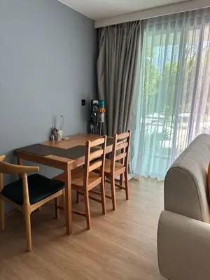 a dining room with a wooden table and chairs at Spacious apartment 600m from the beach in Rawai Beach
