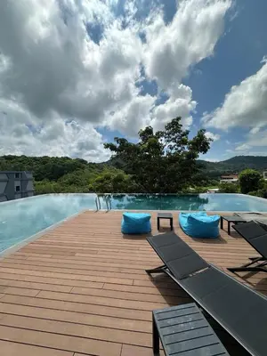 a swimming pool with blue pillows on a wooden deck at Utopia Naiharn Beach B16 in Rawai Beach