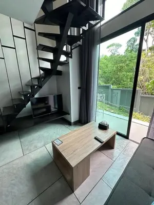a living room with a coffee table and a staircase at Utopia Naiharn Beach B17 in Rawai Beach