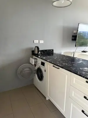 a white laundry room with a washing machine in it at Palmyrah Surin sea view in Surin Beach