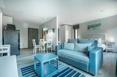 a living room with a blue couch and a table at Studio Apartment by the Sea E413 in Phuket Town