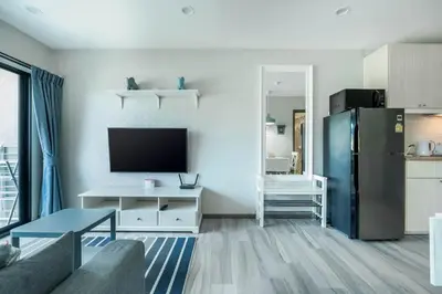 a living room with a refrigerator and a tv at Studio Apartment by the Sea E413 in Phuket Town