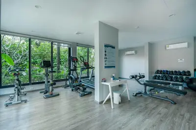 a gym with several treadmills and machines in a room at Studio Apartment by the Sea E413 in Phuket Town