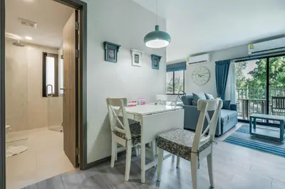 a kitchen and living room with a table and chairs at Studio Apartment by the Sea E413 in Phuket Town